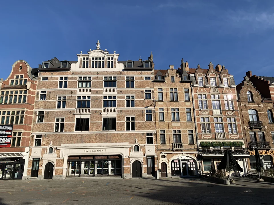 Alignement de façades en brique, dont l’académie de musique, sur la place de la Vaillance à Anderlecht.