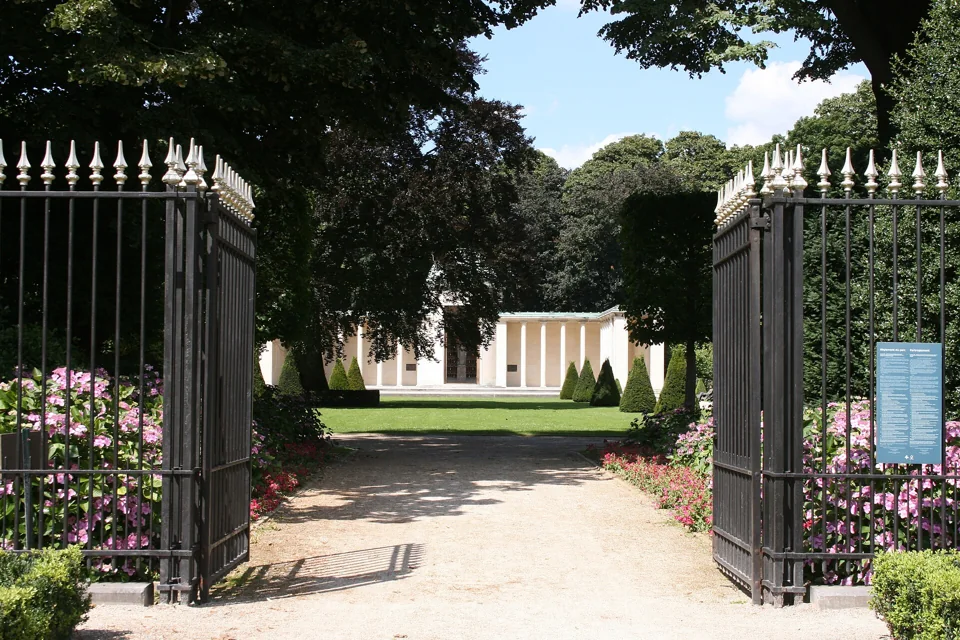 Grilles ouvertes et allée du square du 21 Juillet à Laeken, avec le mémorial de la reine Astrid en fond.