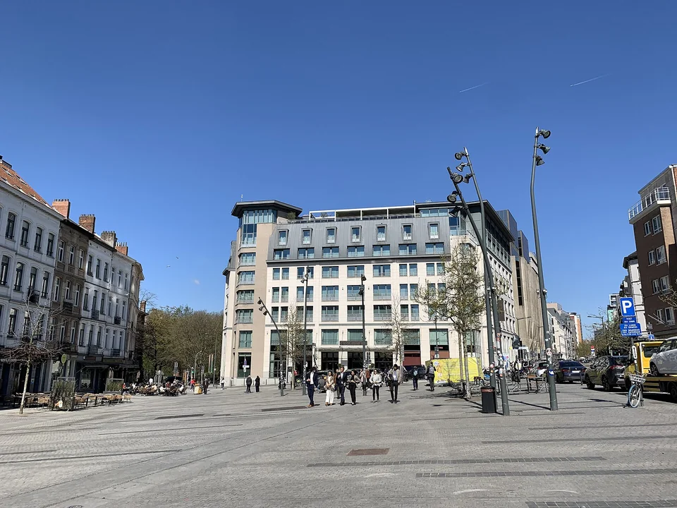 Vue de la place Jourdan et de ses façades sous un ciel bleu.