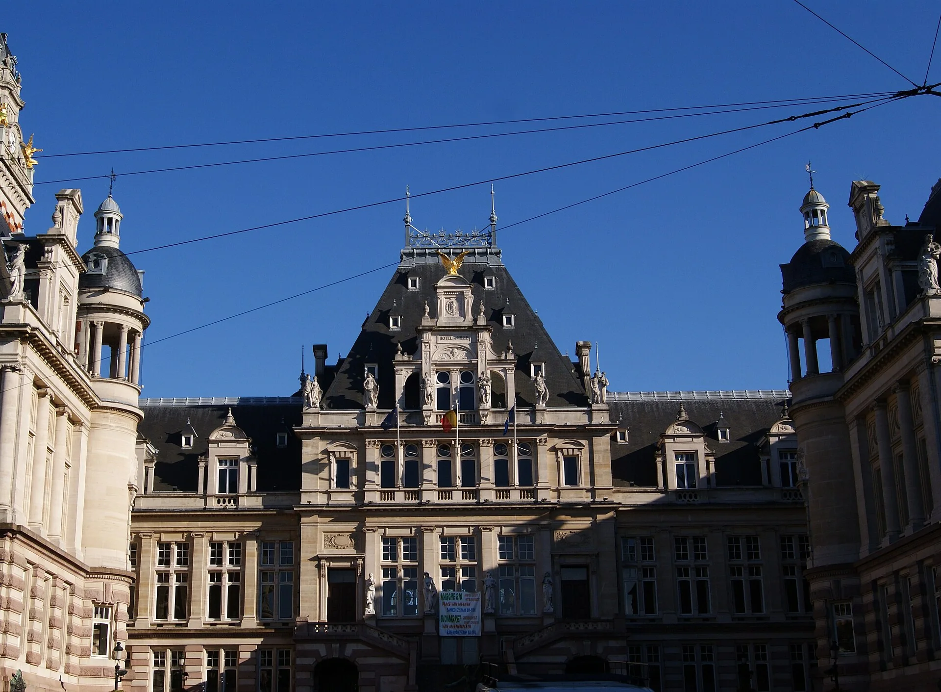 Façade et toiture de l’hôtel de ville de Saint-Gilles, sous un ciel bleu.