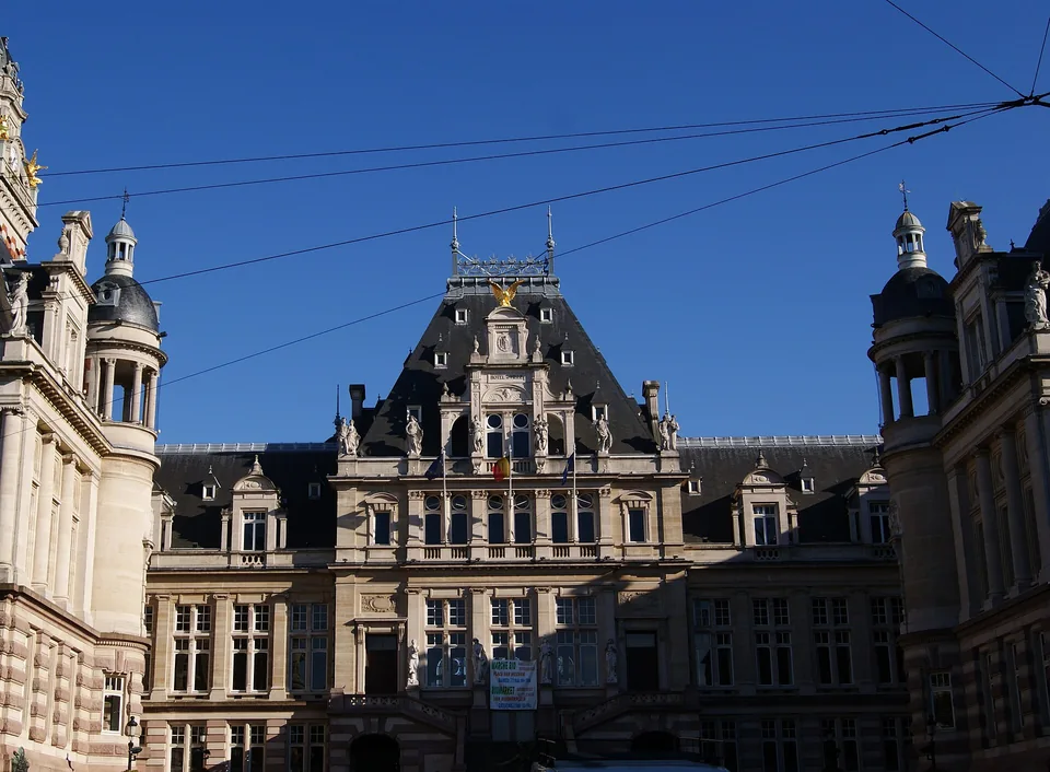 Façade et toiture de l’hôtel de ville de Saint-Gilles, sous un ciel bleu.