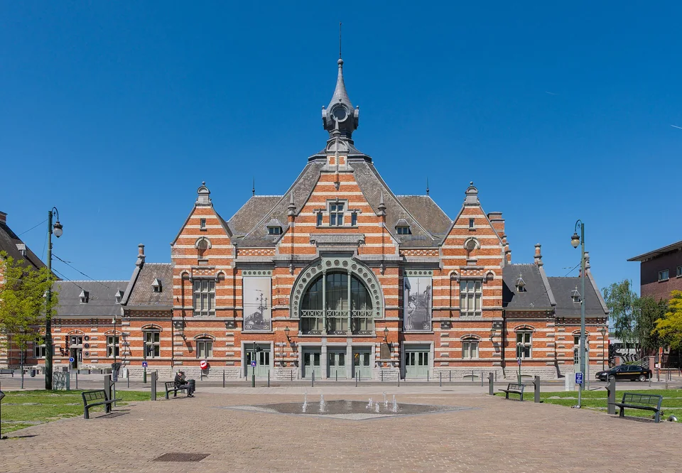 Façade de la gare de Schaerbeek et parvis pavé.