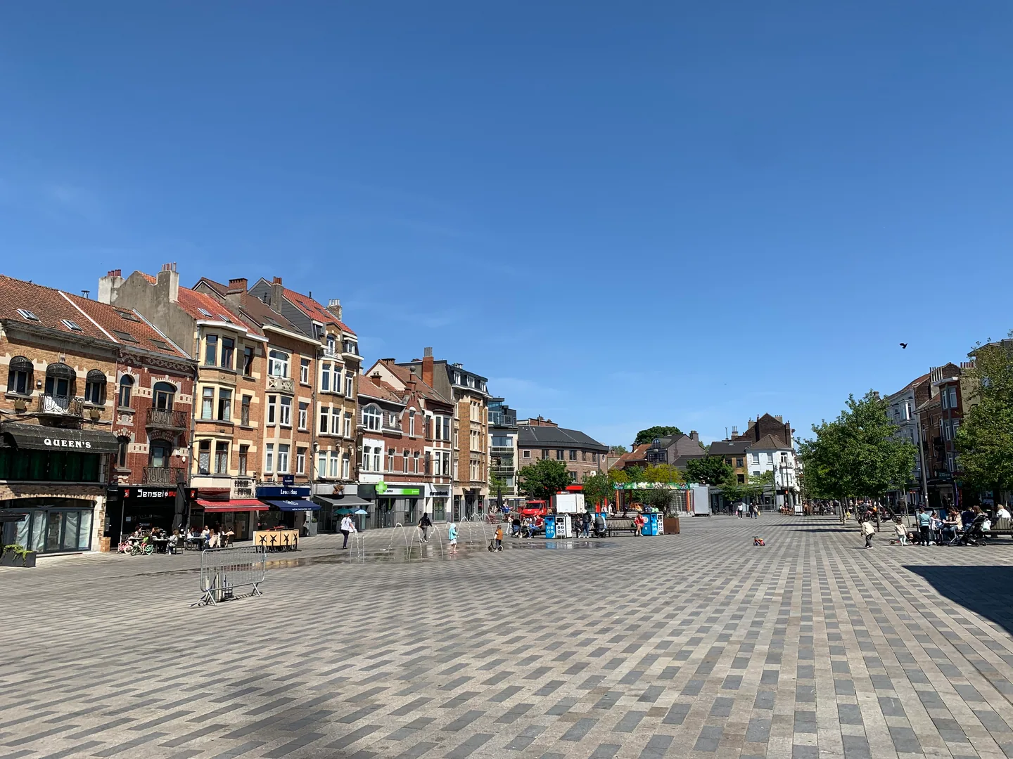 Façades et espace piéton de la place du Miroir à Jette, photographiés en mai 2025.