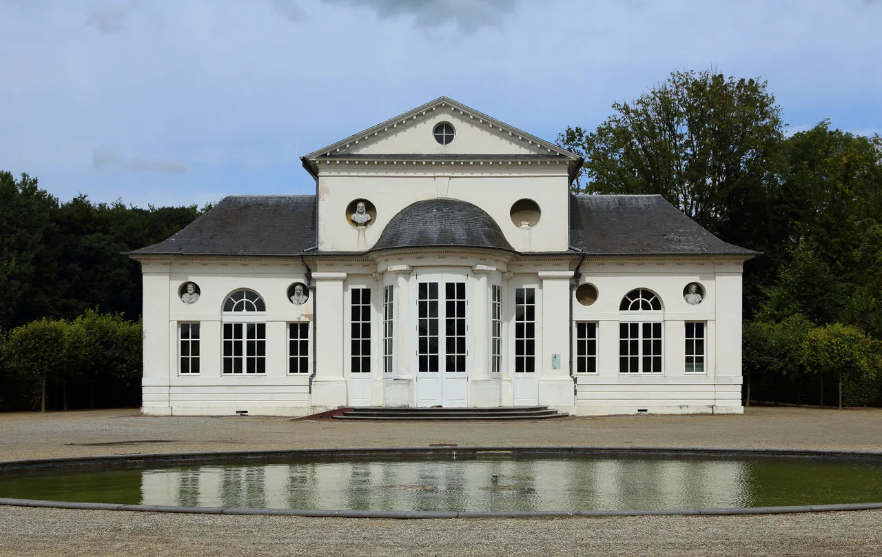 Façade du petit théâtre du domaine du château de Seneffe et bassin au premier plan.