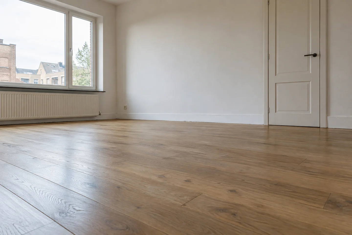Coin de pièce libéré, avec parquet, plinthes et porte accessibles. Illustration.