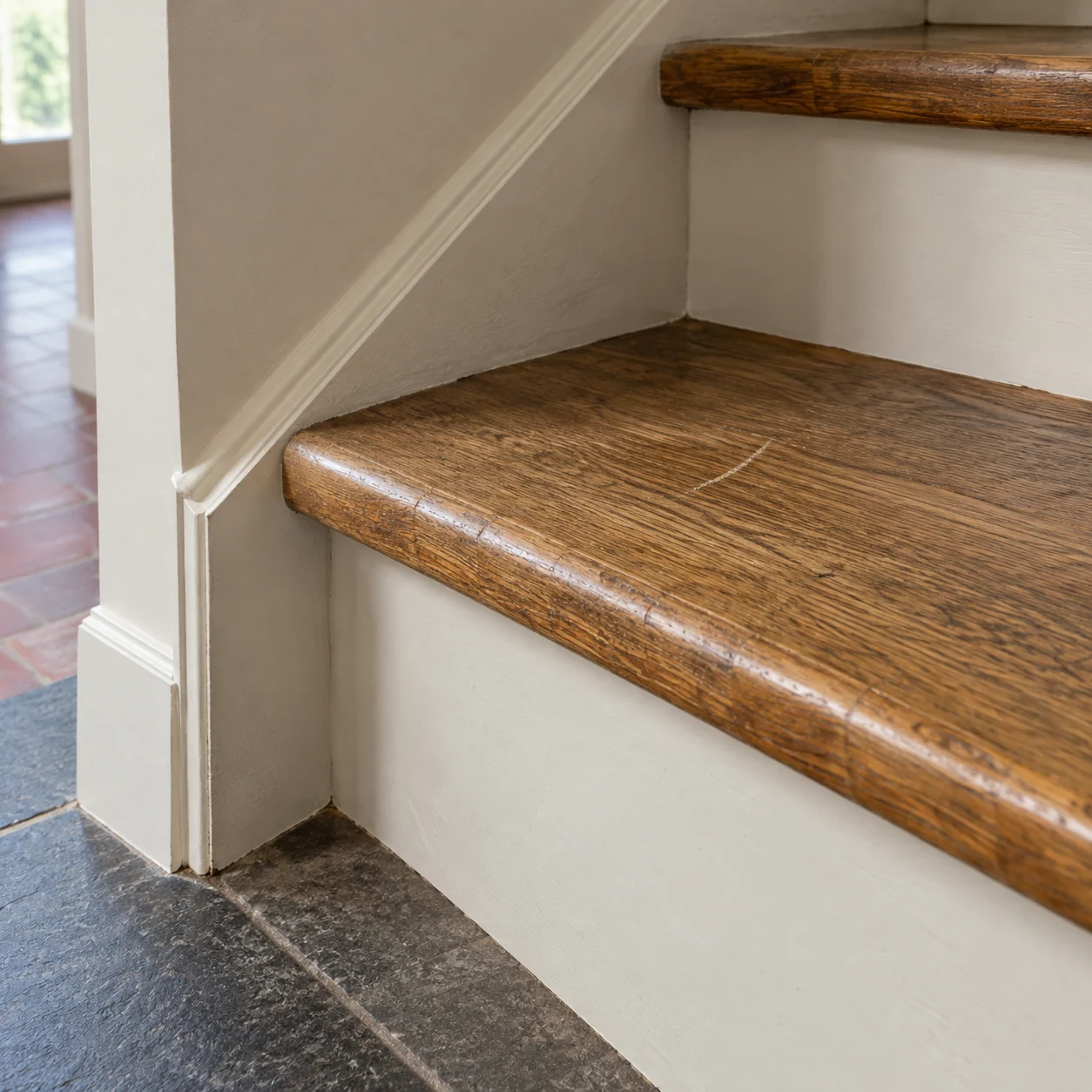 Illustration générée : Marche d’escalier en chêne présentant une patine d’usage et une rayure isolée.