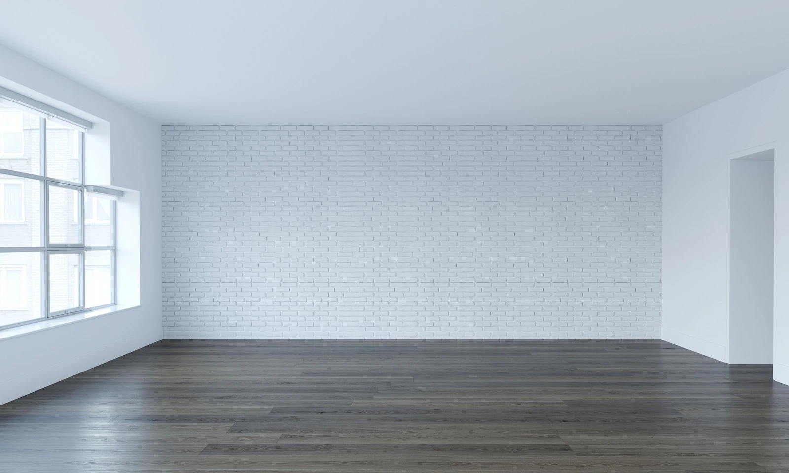 Pièce non meublée aux murs blancs et parquet sombre.