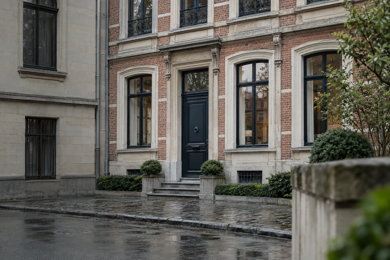 Façades de maisons mitoyennes en brique et pierre, vues depuis une rue pavée