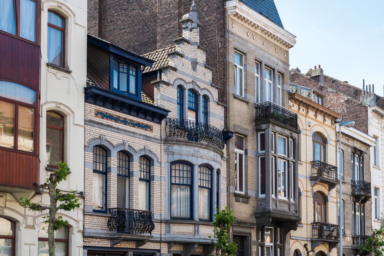 Maisons mitoyennes aux façades de brique claire, bow-windows et balcons en ferronnerie.